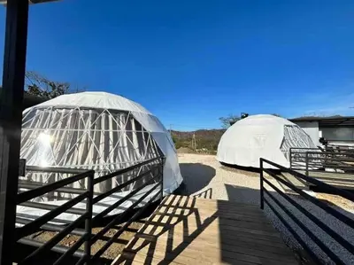two domes are set up in a field at Glamping en Playa Potrero in Potrero