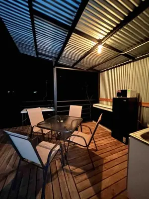 a patio with a table and chairs on a deck at Glamping en Playa Potrero in Potrero