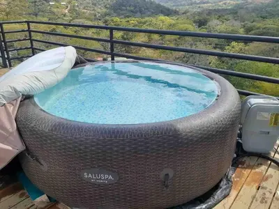 a hot tub sitting on top of a balcony at Glamping en Playa Potrero in Potrero
