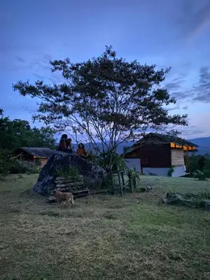 a couple of people sitting on a rock with a dog at Hacienda Monteclaro in Turrialba