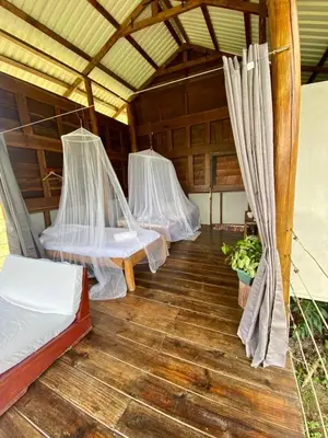 three beds in a room with a wooden floor at Hacienda Monteclaro in Turrialba