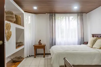 a bedroom with a white bed and a window at Family 2bd apt near Quepos/Manuel Antonio in Quepos
