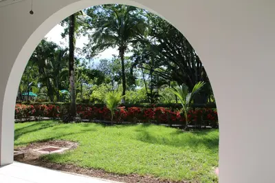 an archway in a park with palm trees and grass at Family 2bd apt near Quepos/Manuel Antonio in Quepos