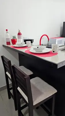 a kitchen with a counter with two chairs and a sink at EcoStudio in San José