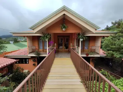 a house with a staircase leading to the front door at Mi Casa Su Casa Monteverde in Monteverde Costa Rica