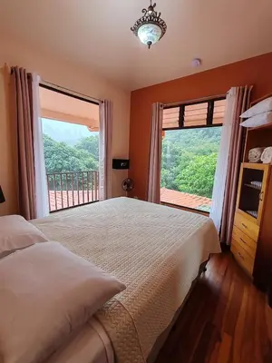 a bedroom with a bed and a large window at Mi Casa Su Casa Monteverde in Monteverde Costa Rica