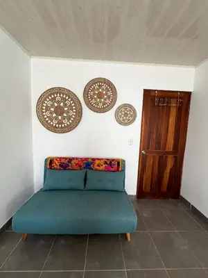 a blue couch in a room with plates on the wall at La Casa Pina Pacifica near La Fortuna in San Ramón