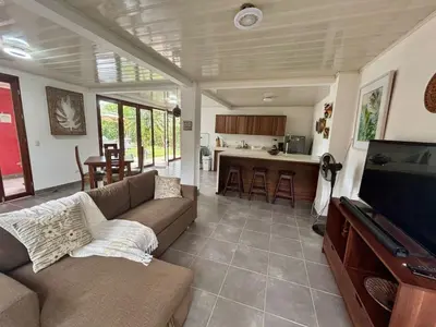 a living room with a couch and a flat screen tv at La Casa Pina Pacifica near La Fortuna in San Ramón