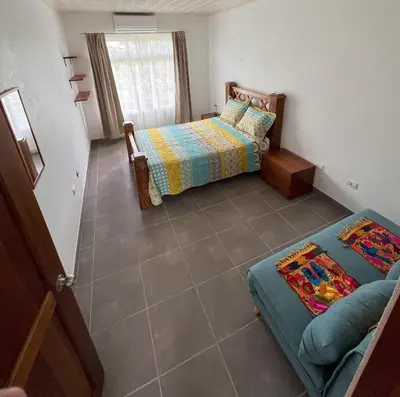 a bedroom with two beds and a couch at La Casa Pina Pacifica near La Fortuna in San Ramón