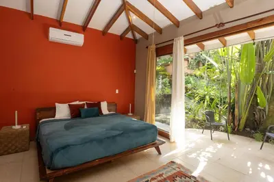 a bedroom with a bed and a large window at Tropical Casa Ventanas with private pool in MA in Quepos