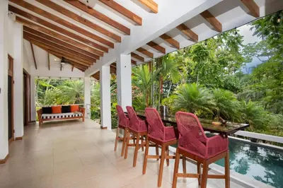 a patio with a table and chairs and a pool at Tropical Casa Ventanas with private pool in MA in Quepos