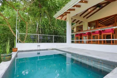 a swimming pool in front of a house at Tropical Casa Ventanas with private pool in MA in Quepos