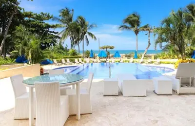 a patio with a table and chairs next to a pool at Acqua Residences 5 Star in Jacó