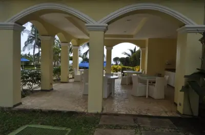 an outdoor patio with tables and chairs in a building at Acqua Residences 5 Star in Jacó