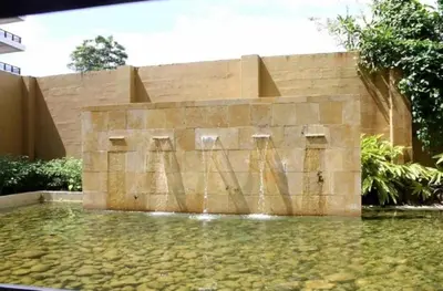 a water fountain in front of a stone wall at Acqua Residences 5 Star in Jacó