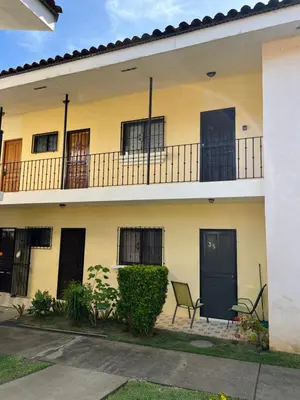 a yellow building with a balcony and a chair at Tropical Beach Second Floor Studio with Hill view in Coco