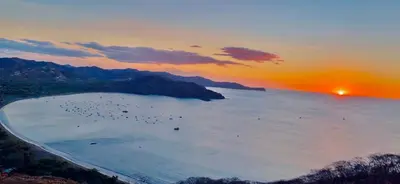 a group of birds in the water at sunset at Tropical Beach Second Floor Studio with Hill view in Coco