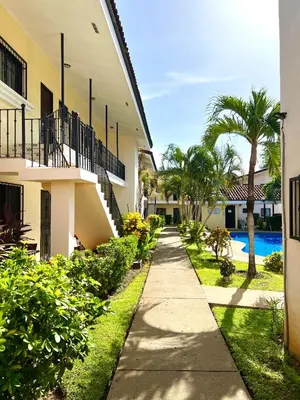 a sidewalk next to a building with a swimming pool at Tropical Beach Second Floor Studio with Hill view in Coco