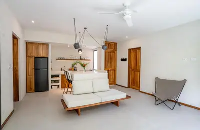 a living room with a white couch and a table at Botanika Suites in Santa Teresa Beach
