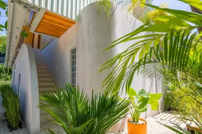 a house with a staircase and some plants at Botanika Suites in Santa Teresa Beach