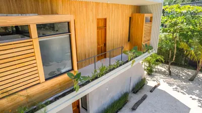 a house with a balcony with plants on it at Botanika Suites in Santa Teresa Beach