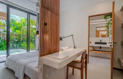a bedroom with a sink and a desk with a mirror at Botanika Suites in Santa Teresa Beach