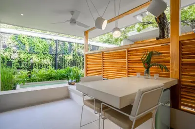 a dining room with a table and some plants at Botanika Suites in Santa Teresa Beach
