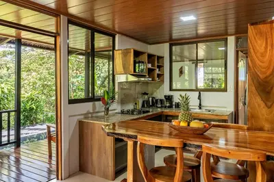 a kitchen with a wooden table and chairs at Finca Sunset Monteverde in Monteverde Costa Rica