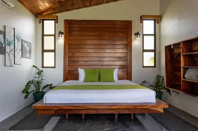 a bedroom with a bed with a wooden headboard at Finca Sunset Monteverde in Monteverde Costa Rica
