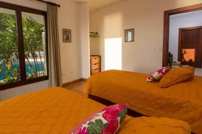 a bedroom with two beds and a view of the ocean at Colores del Viento - by Pura Villas in Uvita