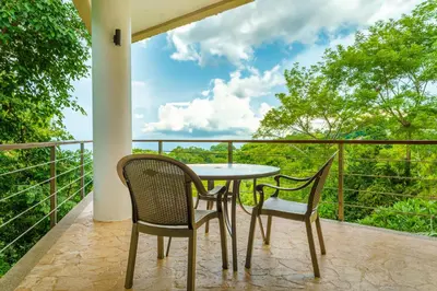 a table and two chairs on a balcony with a view at Colores del Viento - by Pura Villas in Uvita