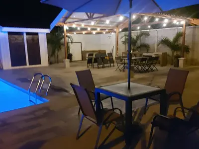 a patio with a table and chairs next to a pool at Casas Doña Juanita in Jacó