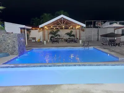 a large blue swimming pool in front of a house at Casas Doña Juanita in Jacó