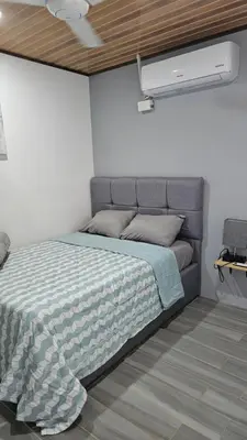 a bedroom with a bed with a blue and white comforter at Casas Doña Juanita in Jacó