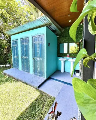 a blue bathroom with a sink in a yard at Pura Vibra Hostel in Fortuna