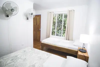 a bedroom with two beds and a window at Pura Vibra Hostel in Fortuna