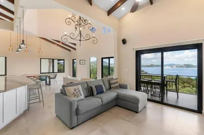 a living room with a couch and a kitchen and a table at Stylish Villa with Brand-New Furniture, Panoramic Ocean Views, and Infinity Swimming Pool & Hot Tub in Potrero