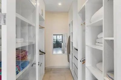 a white walk in closet with white shelves at Stylish Villa with Brand-New Furniture, Panoramic Ocean Views, and Infinity Swimming Pool & Hot Tub in Potrero