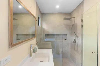 a bathroom with a shower and a sink and a mirror at Stylish Villa with Brand-New Furniture, Panoramic Ocean Views, and Infinity Swimming Pool & Hot Tub in Potrero