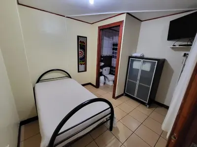 a room with a bed and a bathroom with a toilet at Hotel Valle Verde in San Joaquín