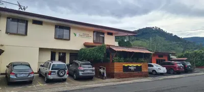 a building with cars parked in a parking lot at Hotel Valle Verde in San Joaquín