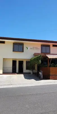a building with a sign on the side of it at Hotel Valle Verde in San Joaquín