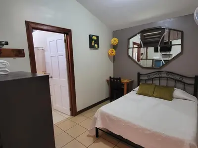 a bedroom with a bed and a mirror on the wall at Hotel Valle Verde in San Joaquín