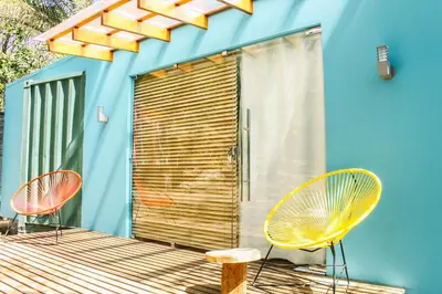 two chairs and a table on a deck next to a building at Casa Rural Aroma de Campo in Curubandé