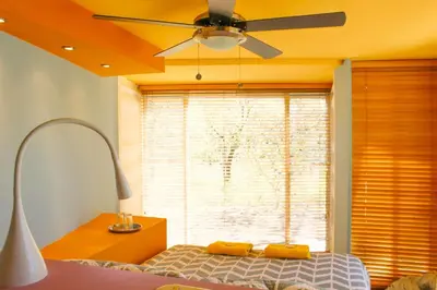 a bedroom with a ceiling fan and a bed and a window at Casa Rural Aroma de Campo in Curubandé