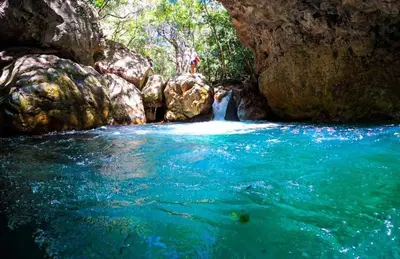 a couple standing in a river in a cave at Casa Rural Aroma de Campo in Curubandé
