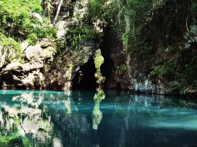 a cave in a river with blue water at Casa Rural Aroma de Campo in Curubandé