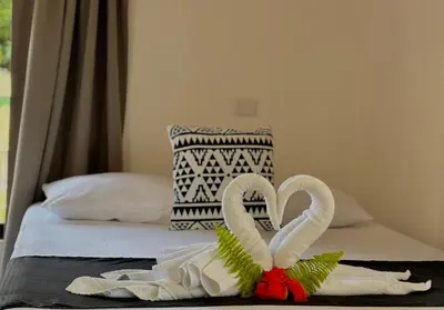 a bed with two swans made out of towels at Carey Lodging in Tortuguero