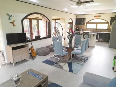 a living room with a table and blue chairs at TOP RATED - Stunning Lake Arenal 2 Bed Country House in Tronadora