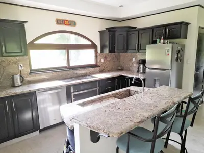 a kitchen with black cabinets and a marble counter top at TOP RATED - Stunning Lake Arenal 2 Bed Country House in Tronadora